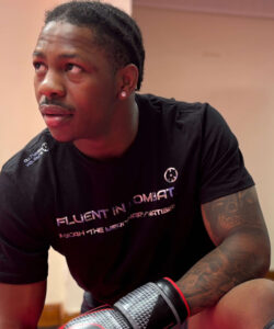 CV…☮ Micah “The Mercenary" Matibiri Fluent In Combat. Athletic-Fit T-Shirt